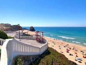 einen Strand mit Liegestühlen und Sonnenschirmen und dem Meer in der Unterkunft Nice apartment in Santa Cruz with balcony in Santa Cruz