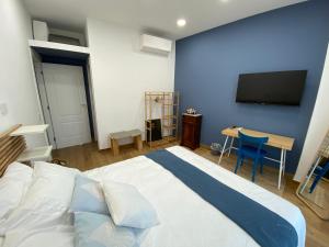 a bedroom with a large bed with a tv on the wall at Terrazza panorama centro storico in Naples