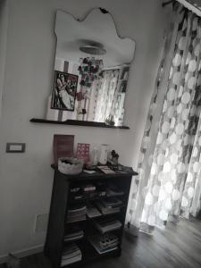 a room with a shelf with books and a mirror at La casa di Piera e Gina in Perugia