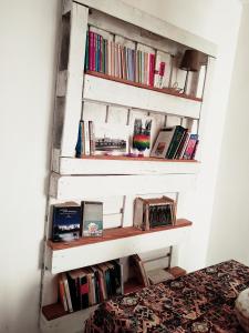 a white book shelf with books on it at La casa di Piera e Gina in Perugia