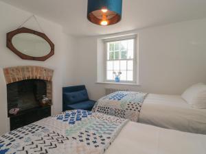 een slaapkamer met twee bedden en een spiegel bij Mollys Cottage in Dorchester