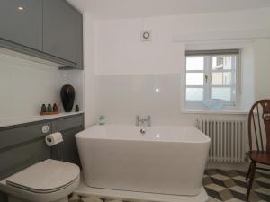 een badkamer met een wit bad en een toilet bij Mollys Cottage in Dorchester +18 foto's