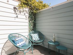 twee stoelen en twee tafels met kussens op een terras bij Mollys Cottage in Dorchester