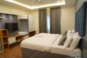 a bedroom with a large bed and a television at Mevid Hotels in Hyderabad