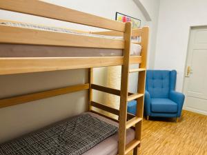 Zimmer mit Etagenbett, 2 Etagenbetten und einem blauen Stuhl in der Unterkunft Schlosspark Apartment I 80qm I 3 Betten I bei Pirna in Heidenau