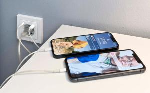 two cell phones sitting on a table next to an outlet at Cozy Inn Schladern in Windeck