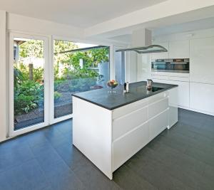 a kitchen with white cabinets and a black counter top at Cozy Inn Schladern in Windeck