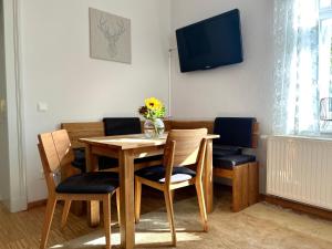 ein Esszimmer mit einem Holztisch und Stühlen in der Unterkunft Schlosspark Apartment I 80qm I 3 Betten I bei Pirna in Heidenau