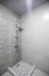 ein Bad mit einer Dusche und einer gefliesten Wand in der Unterkunft Apartment Kutaisi 248 in Kutaissi
