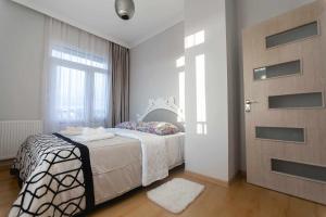 a bedroom with a white bed and a door at Apartment Kutaisi 248 in Kutaisi