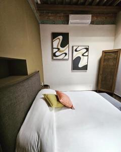 a bedroom with a white bed with two pictures on the wall at Hotel Úrsula Concept in Querétaro