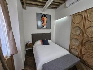 a small bedroom with a bed and a picture on the wall at Hotel Úrsula Concept in Querétaro