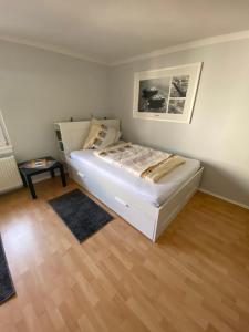 ein weißes Bett in einem Zimmer mit Holzboden in der Unterkunft Casa Türk in Bad Nauheim