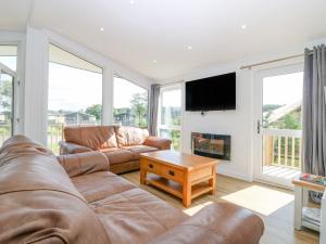 a living room with a couch and a fireplace at Lodge 14 - The Tay Family in Perth