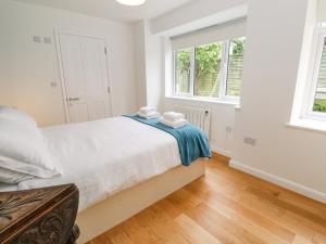 a bedroom with a large bed and two windows at James' Place in Falmouth