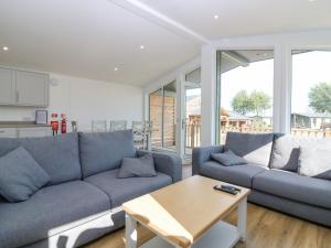 a living room with two blue couches and a table at Lodge 16 - The Ericht Family in Perth