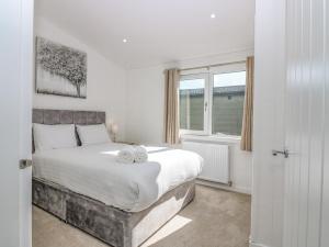 1 dormitorio con 1 cama grande y 2 toallas. en Lodge 16 - The Ericht Family, en Perth