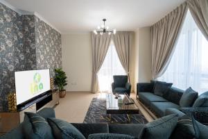 a living room with blue couches and a tv at INA HOMES - 2BHK Residences Tower 1 in Dubai