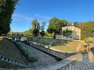 un pont sur une rivière avec des plantes dans l'établissement Le relais de Mantelot, à Châtillon-sur-Loire