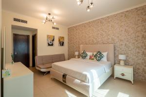 a bedroom with a bed and a chair in it at INA HOMES - 2BHK Residences Tower 1 in Dubai