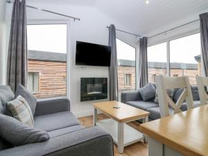 a living room with two couches and a table at Lodge 18 - Ruthven Hideaway in Perth