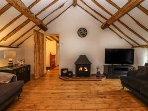 a living room with a fireplace and a tv at 1 White House Cottages in Ross on Wye