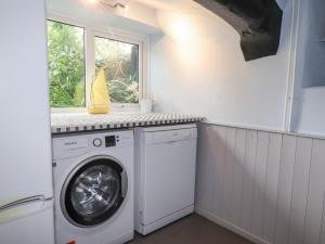 lavadero con lavadora y ventana en Ewyn Y Mor en Beaumaris