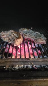 two pieces of meat are cooking on a grill at Hotel El Sombrerito in Vilaflor