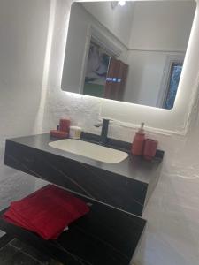 a bathroom with a sink and a mirror at Cozy apartment near Paris square in Amman