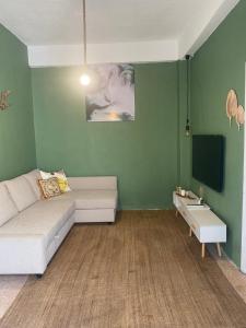 a living room with a couch and a flat screen tv at Cozy apartment near Paris square in Amman