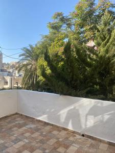 een wit hek met een boom op de achtergrond bij Cozy apartment near Paris square in Amman