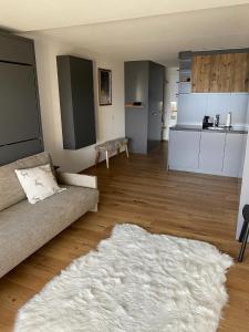- un salon avec un canapé et un tapis blanc dans l'établissement Magnifique studio Anzère, à Anzère
