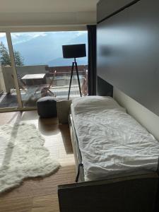Schlafzimmer mit einem Bett und Blick auf einen Balkon in der Unterkunft Magnifique studio Anzère in Anzère