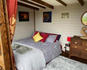 a bedroom with a bed and a dresser at Cherry Tree Glamping Lodge in Wellington