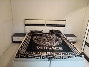 Schlafzimmer mit einem Bett mit einer schwarzen und weißen Bettdecke in der Unterkunft Skopje Hostel in Skopje