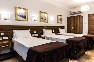 a hotel room with two beds and two cabinets at Slimiza Suites in Sliema