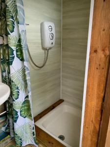 a bathroom with a bath tub with a shower curtain at Cherry Tree Glamping Lodge in Wellington