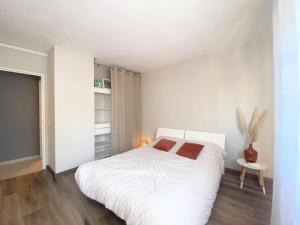 a white bedroom with a large bed and a table at Apartment Antibes city-center & port in Antibes
