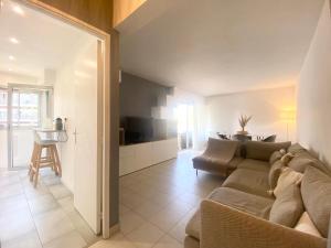 sala de estar con sofá, TV y mesa en Apartment Antibes city-center & port, en Antibes