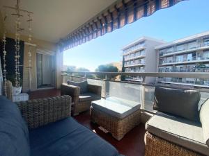 a balcony with wicker furniture and a view of a building at Apartment Antibes city-center & port in Antibes
