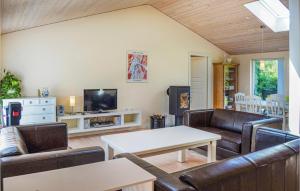 VestervigにあるAmazing Home In Vestervig With 3 Bedrooms, Sauna And Wifiのリビングルーム(革製家具、テーブル付)