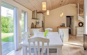 a kitchen and dining room with a white table and chairs at Cozy Home In Vestervig With Kitchen in Vestervig