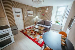 a living room with a table and a couch at KENDAL HOLIDAY FLATS in Kendal