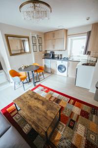 a living room with a table and a kitchen at KENDAL HOLIDAY FLATS in Kendal