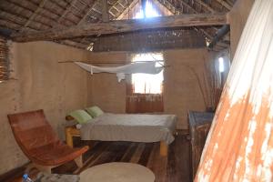 a room with a bed and a hammock hanging from the ceiling at Iharana Bush Camp in Ambondromifehy