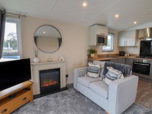 a living room with a couch and a fireplace at Woody Ray in Bridlington