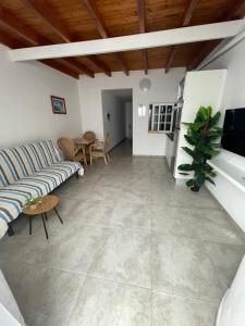 ein Wohnzimmer mit einem Sofa und einem Tisch in der Unterkunft Apartamentos Elena in Lajares