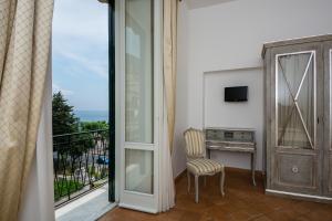a room with a balcony with a chair and a desk at Relais San Giacomo in Maiori