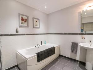 福爾柯克的住宿－Shieldhill Farm House，白色的浴室设有浴缸和水槽。