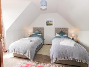 a bedroom with two beds in a attic at Shieldhill Farm House in Falkirk